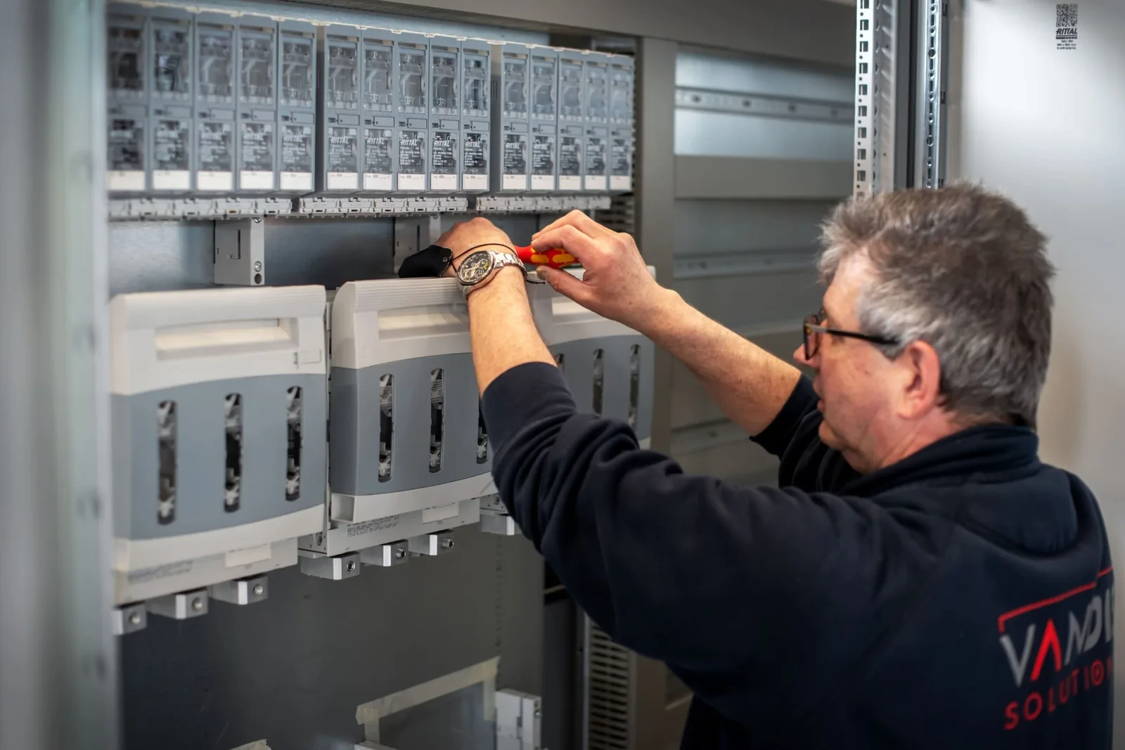 Monteur werkt aan regelaars binnen een installatieproject