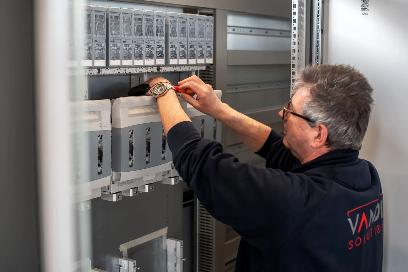 Engineer werkt aan PLC-regelaars in een installatie